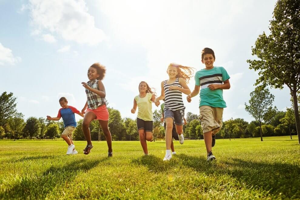 Niños corriendo y jugando al aire libre en el campamento de verano